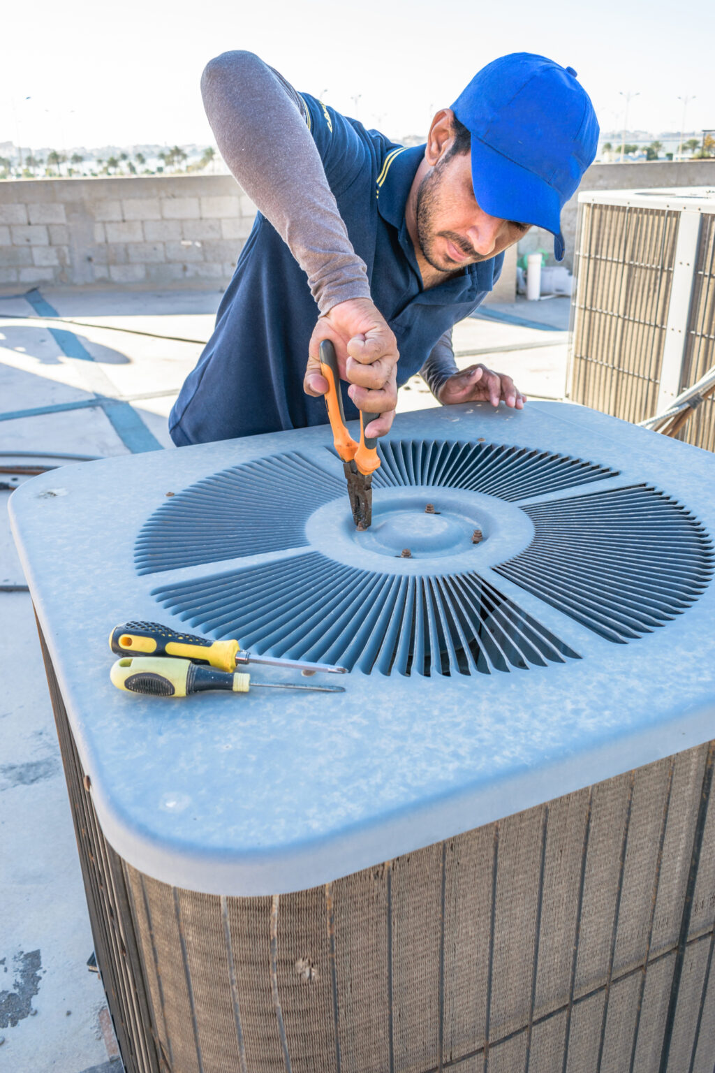 A professional HVAC technician fixing a commercial AC unit