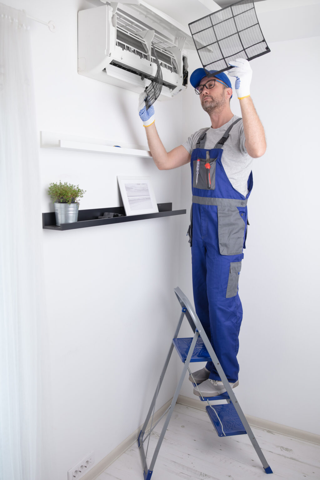 Technician cleaning and maintaining ductless air conditioning unit