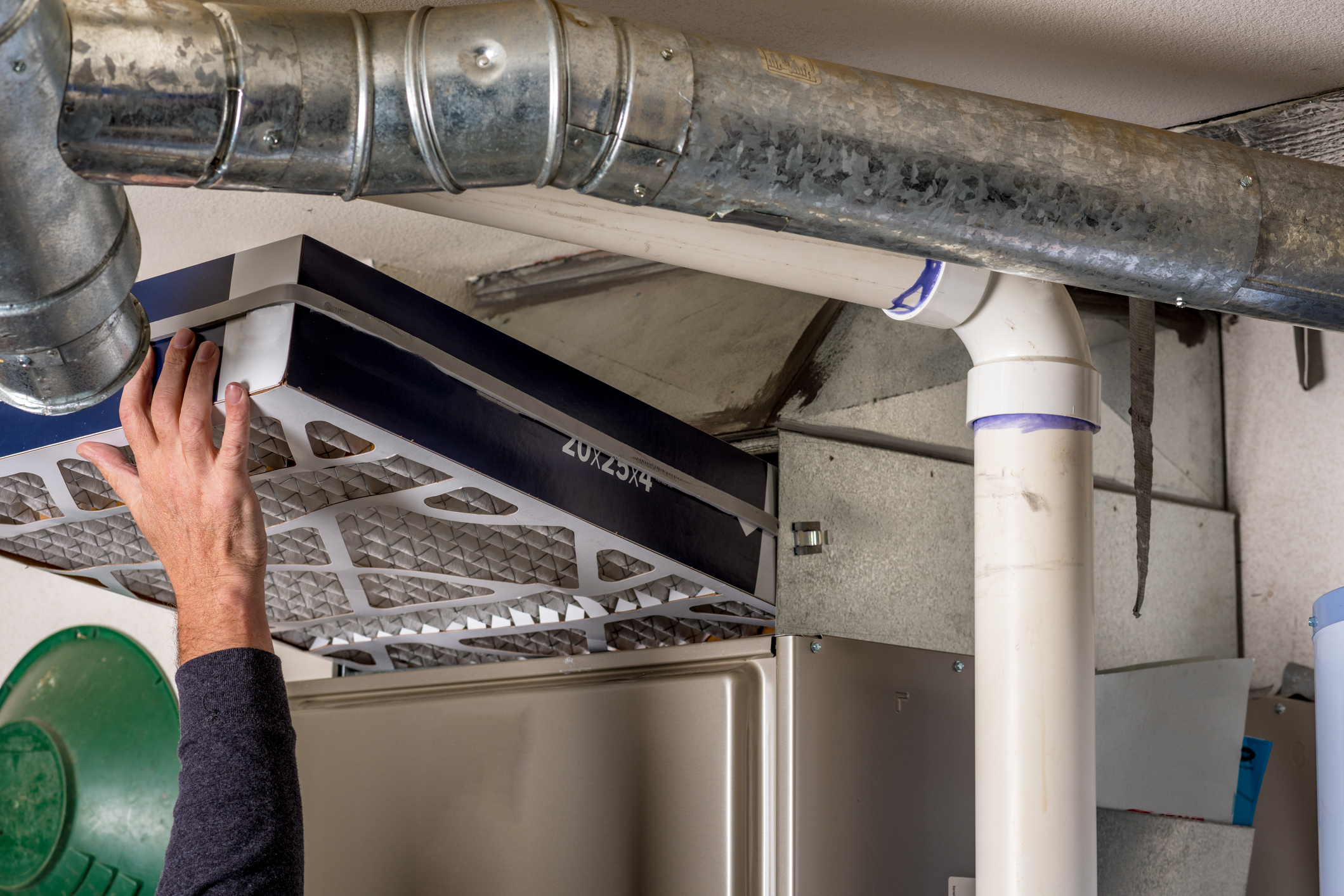 Handyman replaces a furnace filter with a clean one