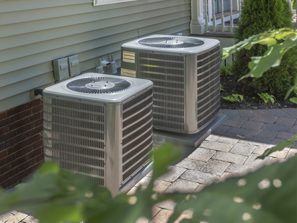 Dual HVAC units installed in the backyard of a home