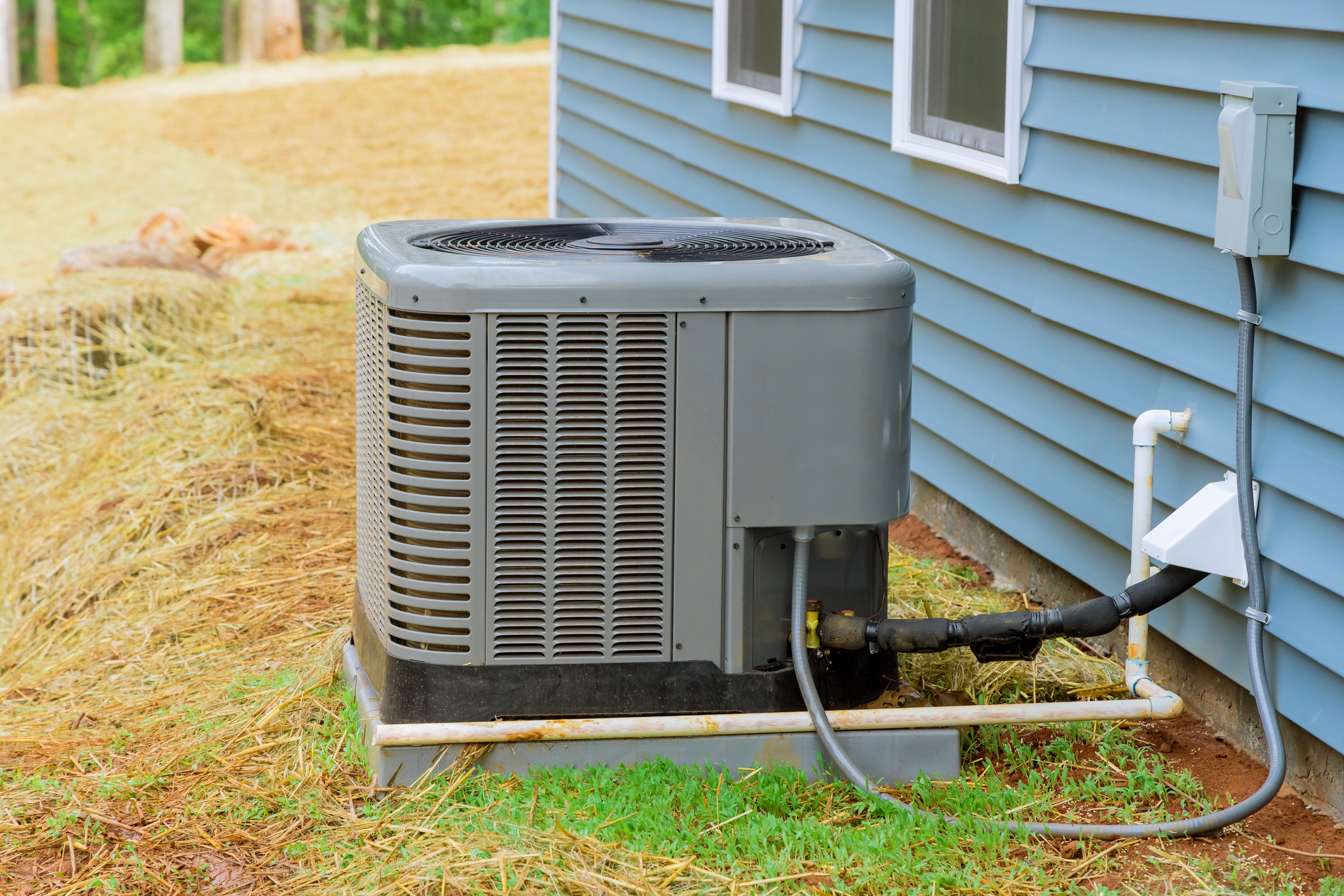 Newly installed AC unit outside of a blue home 