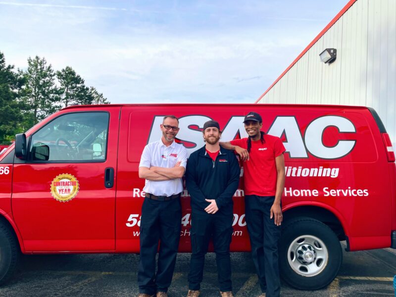 Three Isaac technicians in front of a service van