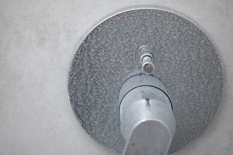 Dirty calcified shower faucet with limescale on it