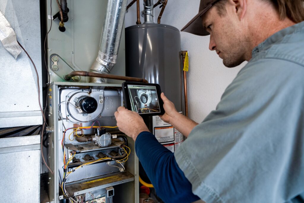 HVAC technician taking a photo of a furnace