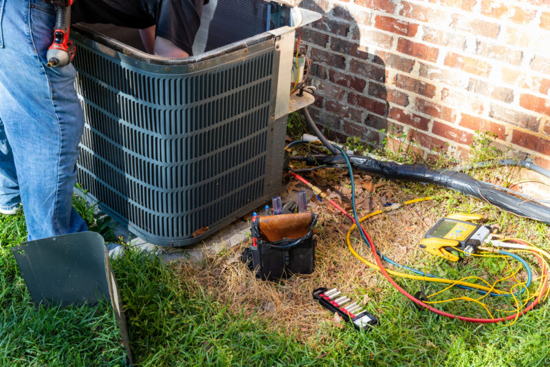HVAC technician performing a repair on a residential AC unit