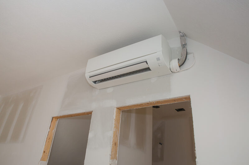 Mini-split ductless air conditioning unit installed in unfinished room