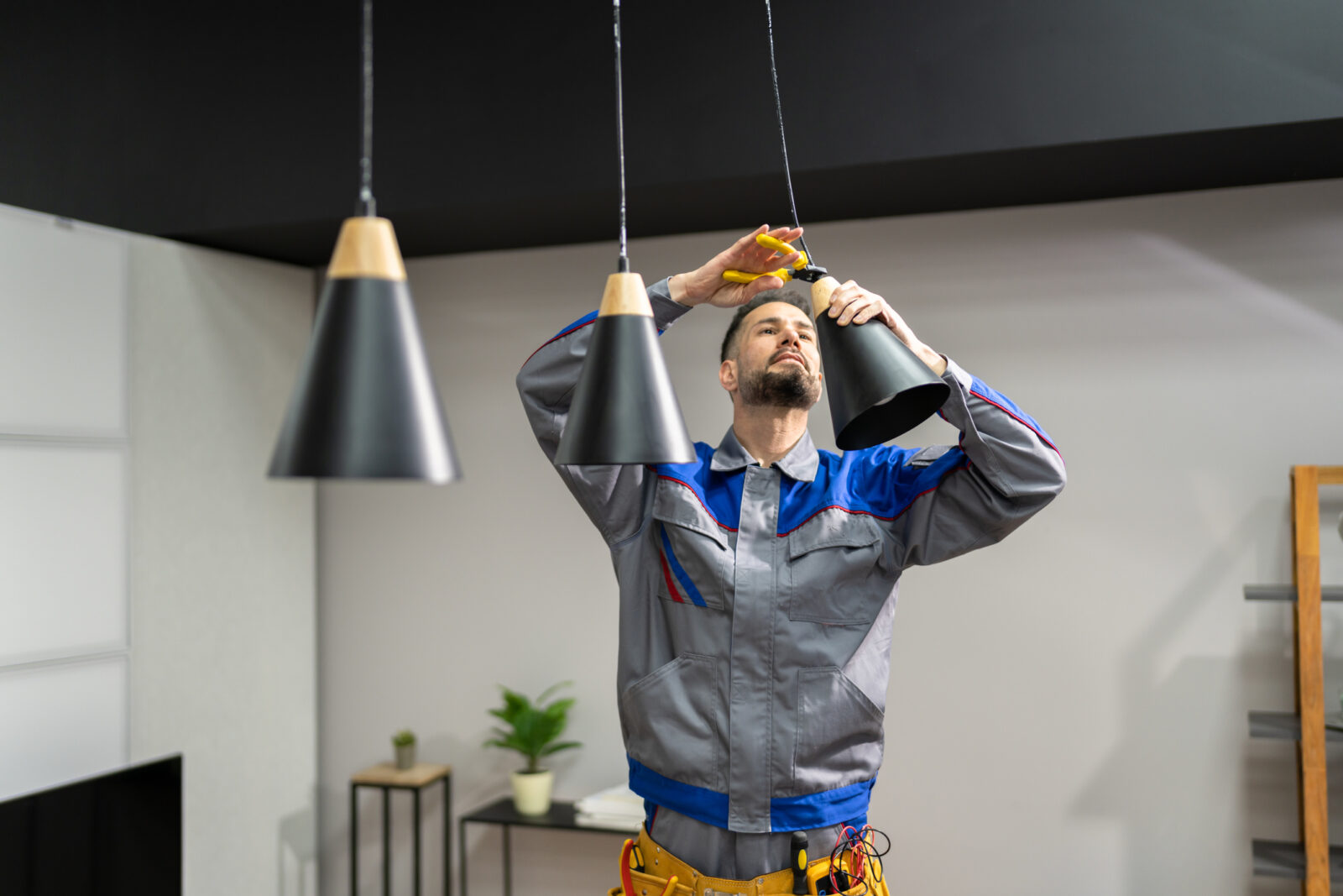 electrician installing new pendant lighting in a home